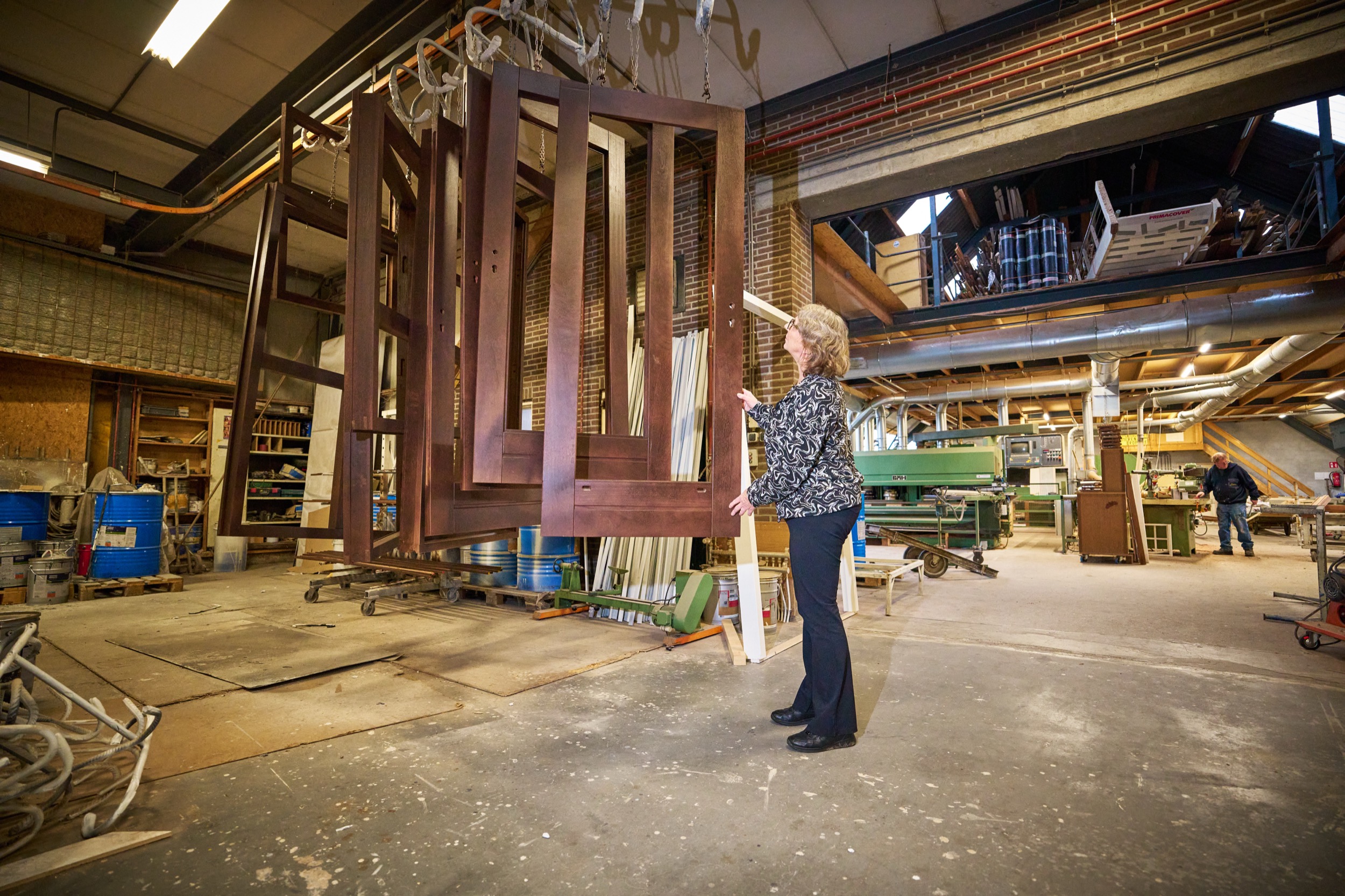 Vrouw in patroonblouse inspectie in industrieel bedrijf met houten ramen, Zijen Drenthe — Stefan Segers Fotografie
