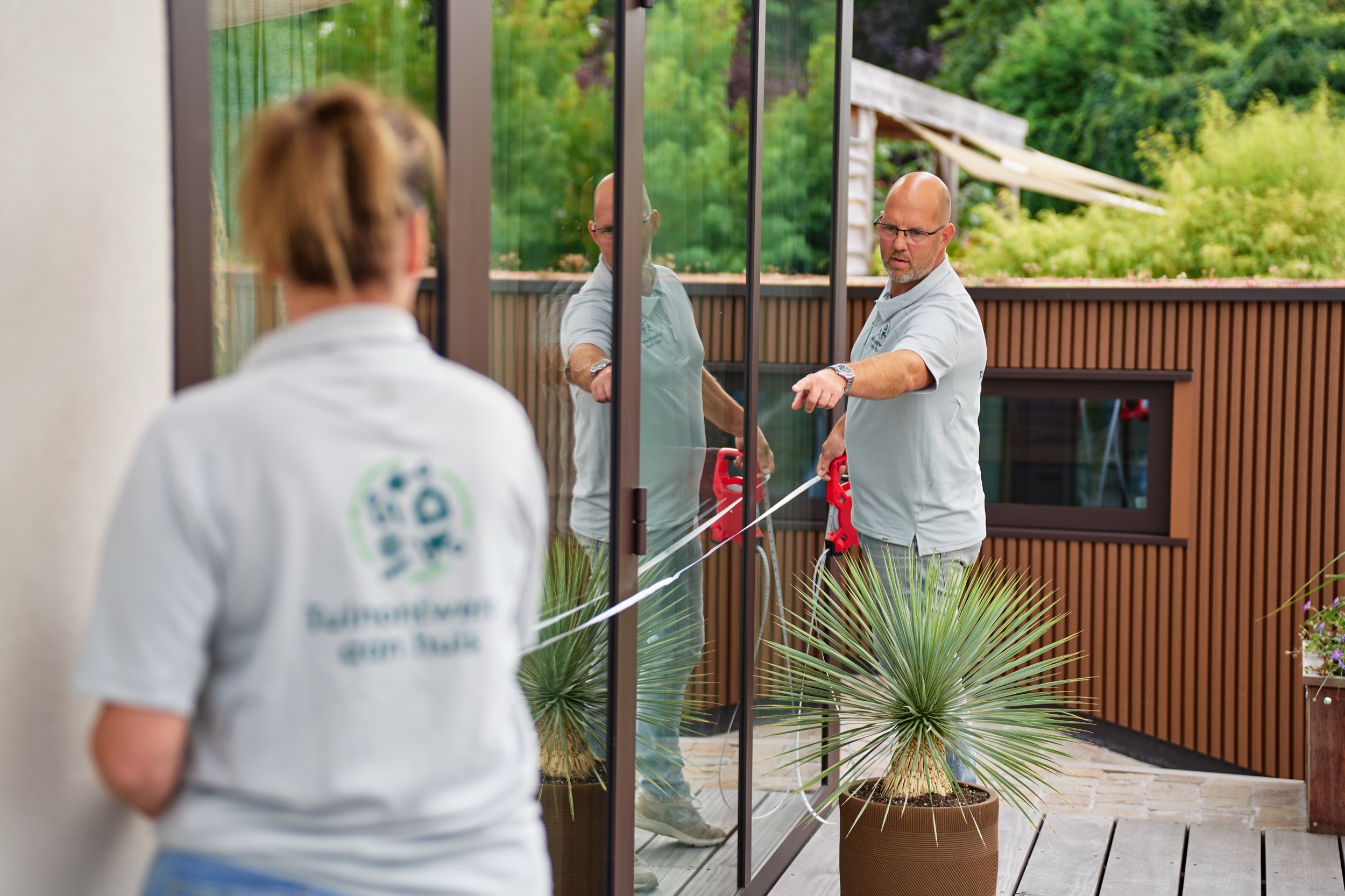 Twee medewerkers in gesprek achter glazen deur, moderne tuinontwerp kantoor Bleiswijk — Stefan Segers Fotografie