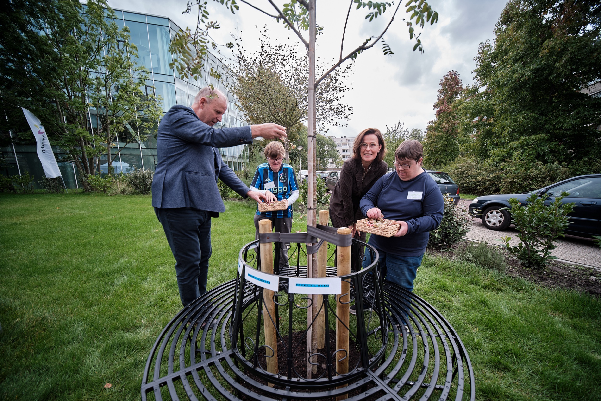 Vier personen planten jonge boom bij opening nieuw pand Middin Iris, Naaldwijk — Stefan Segers Fotografie