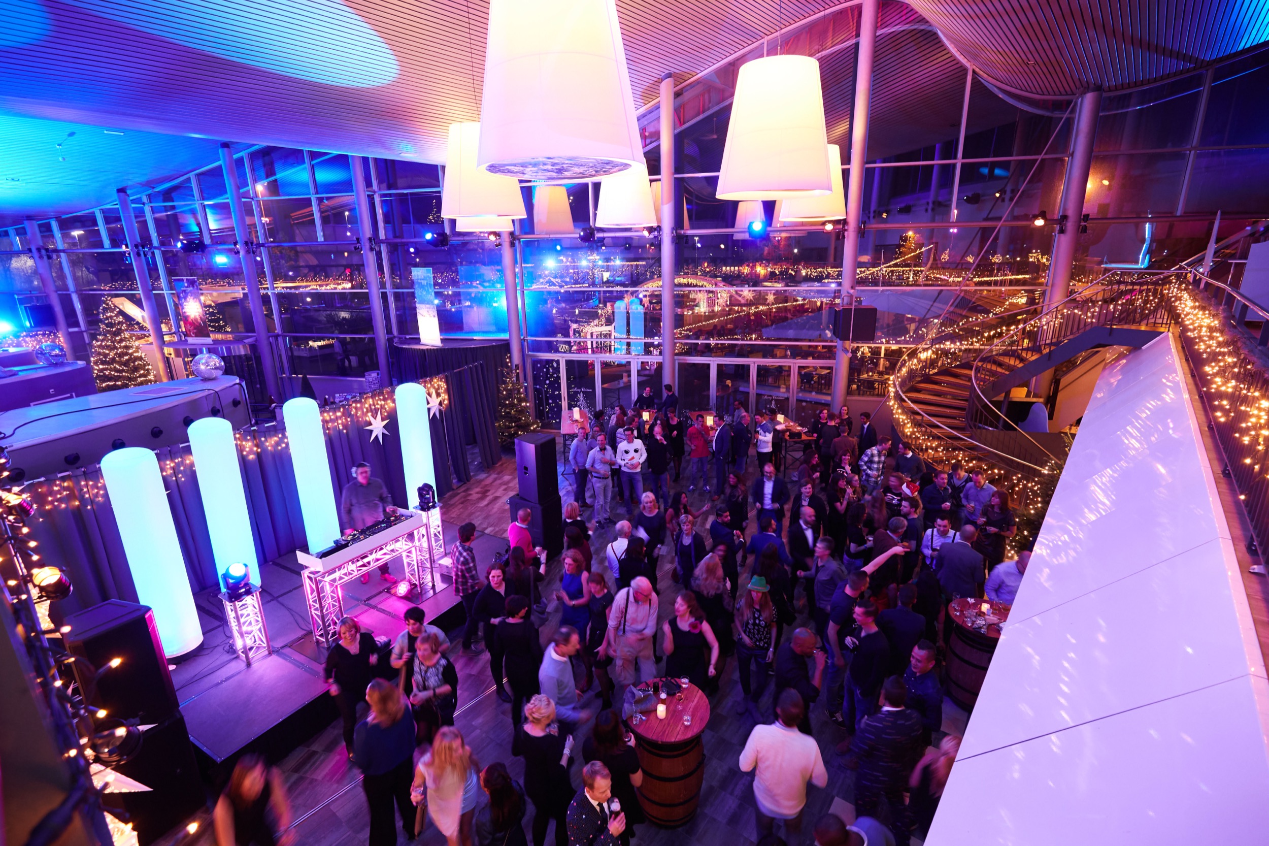 Zakenmedewerkers netwerken op verlichte rooftopterras met uitzicht op verlichting, Rabobank kerstborrel Madurodam Den Haag — Stefan Segers Fotografie