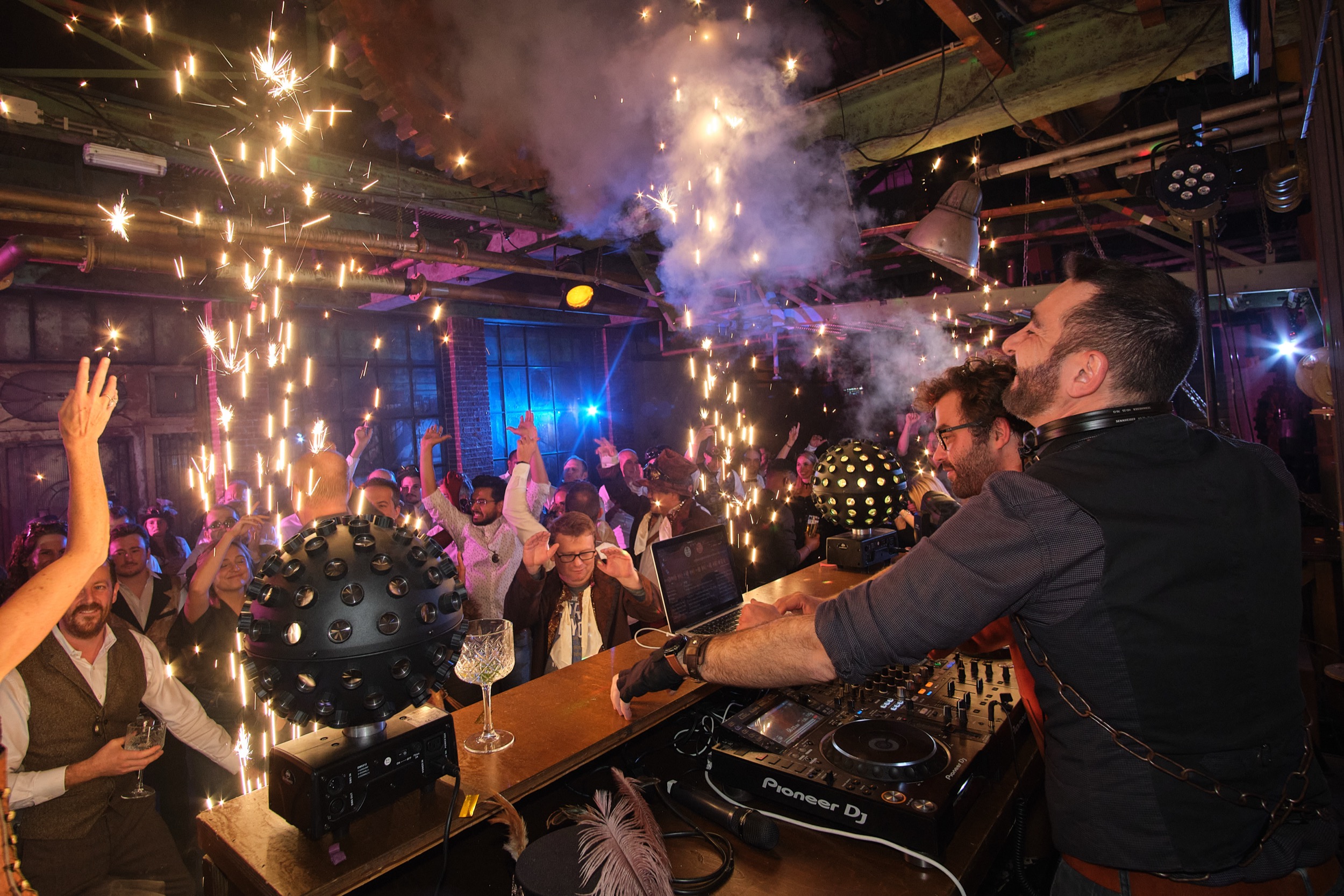 DJ achter turntables speelt voor energiek publiek onder sparklers, ALD Automotive evenement, Geertruidenberg — Stefan Segers Fotografie