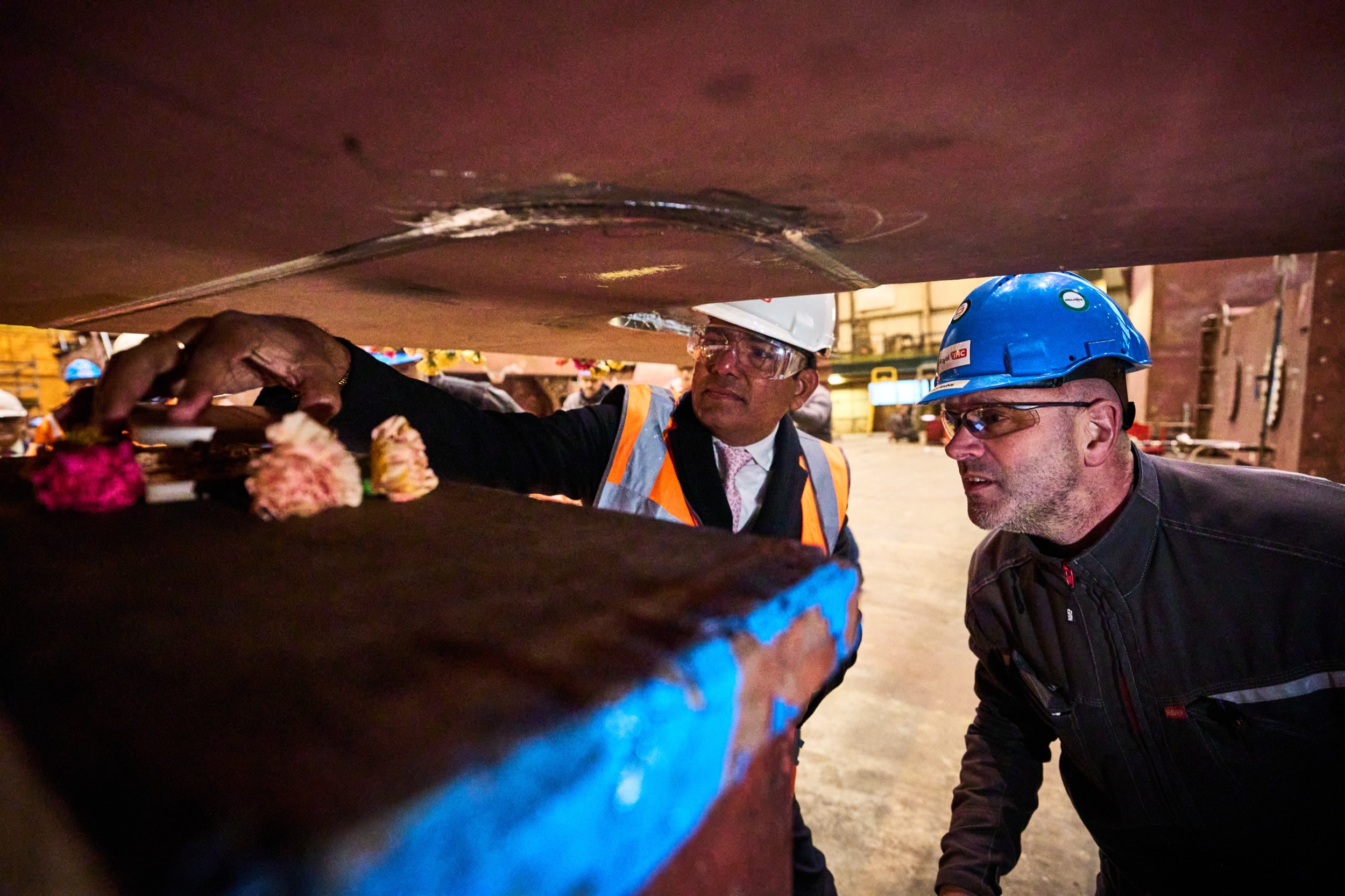 Twee mannen in veiligheidshelm en oranje hesje inspecteren staalconstructie tijdens keellegging, Royal IHC Kinderdijk — Stefan Segers Fotografie