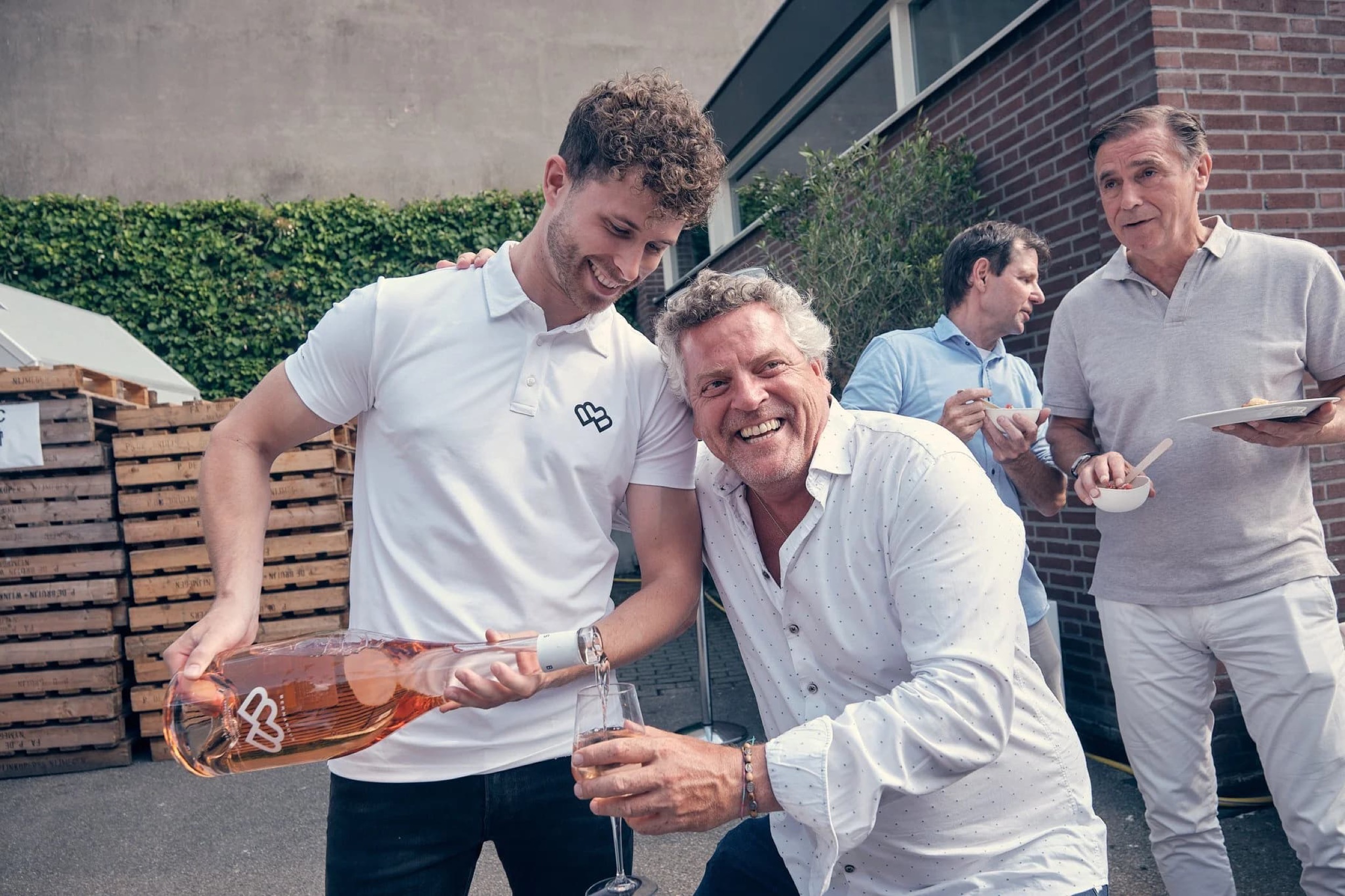 Mannen proostten met roséwijn tijdens zakelijk netwerkevent op terras, gezellige sfeer — Stefan Segers Fotografie
