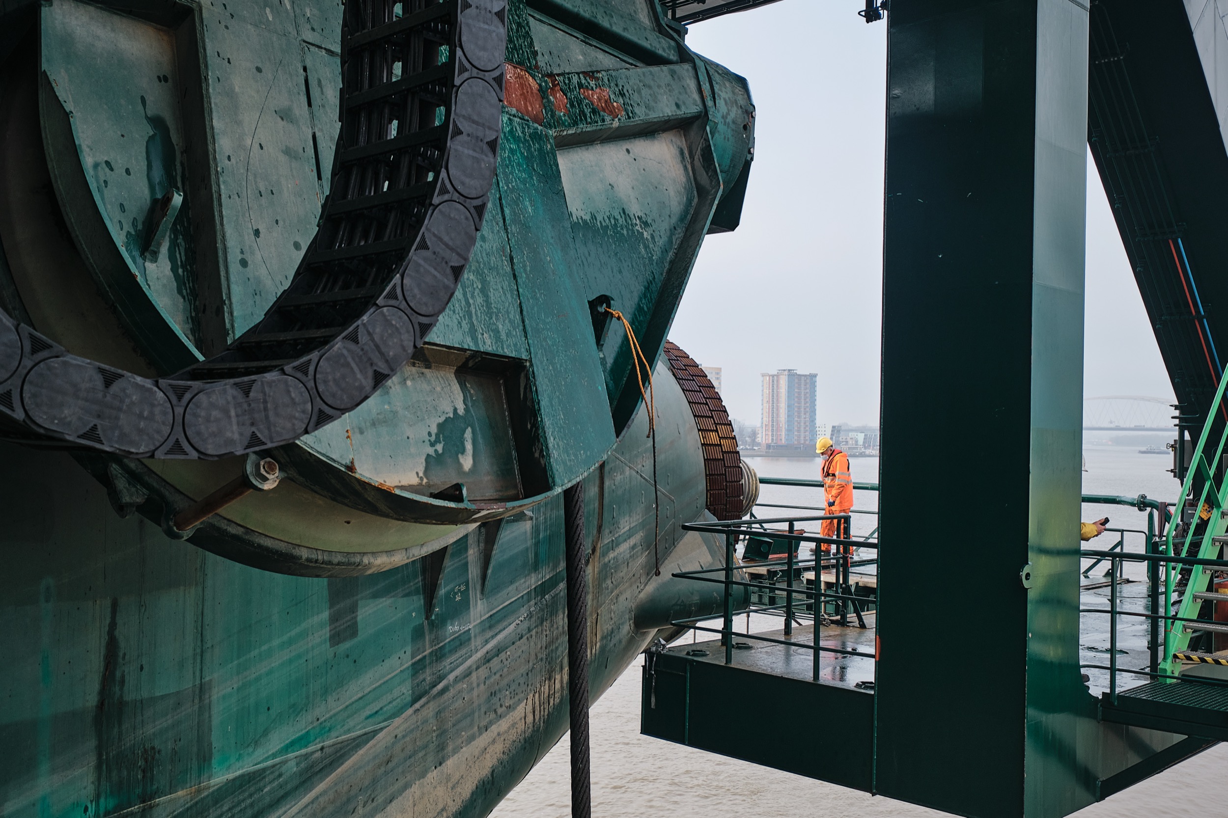 Werknemer in oranje veiligheidskleding inspecteert industriële scheepsmachinery, Krimpen aan den IJssel — Stefan Segers Fotografie