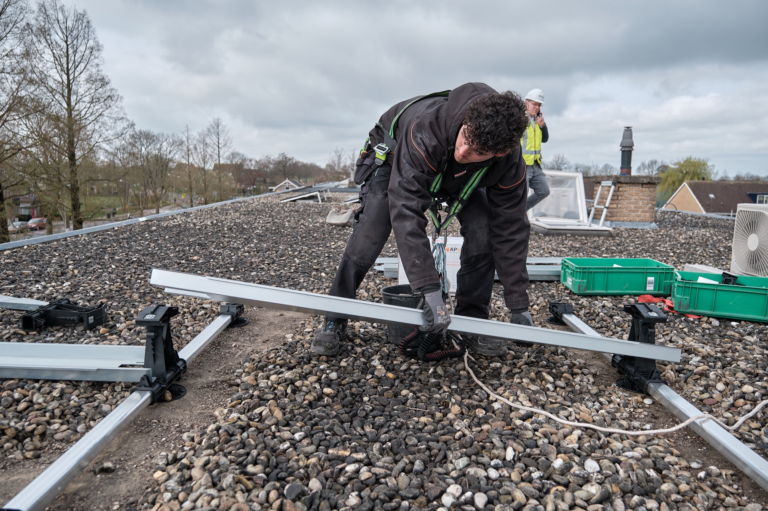 Monteur installeert zonnepanelen op dak, veiligheidsuitrusting, Nieuwkoop — Stefan Segers Fotografie