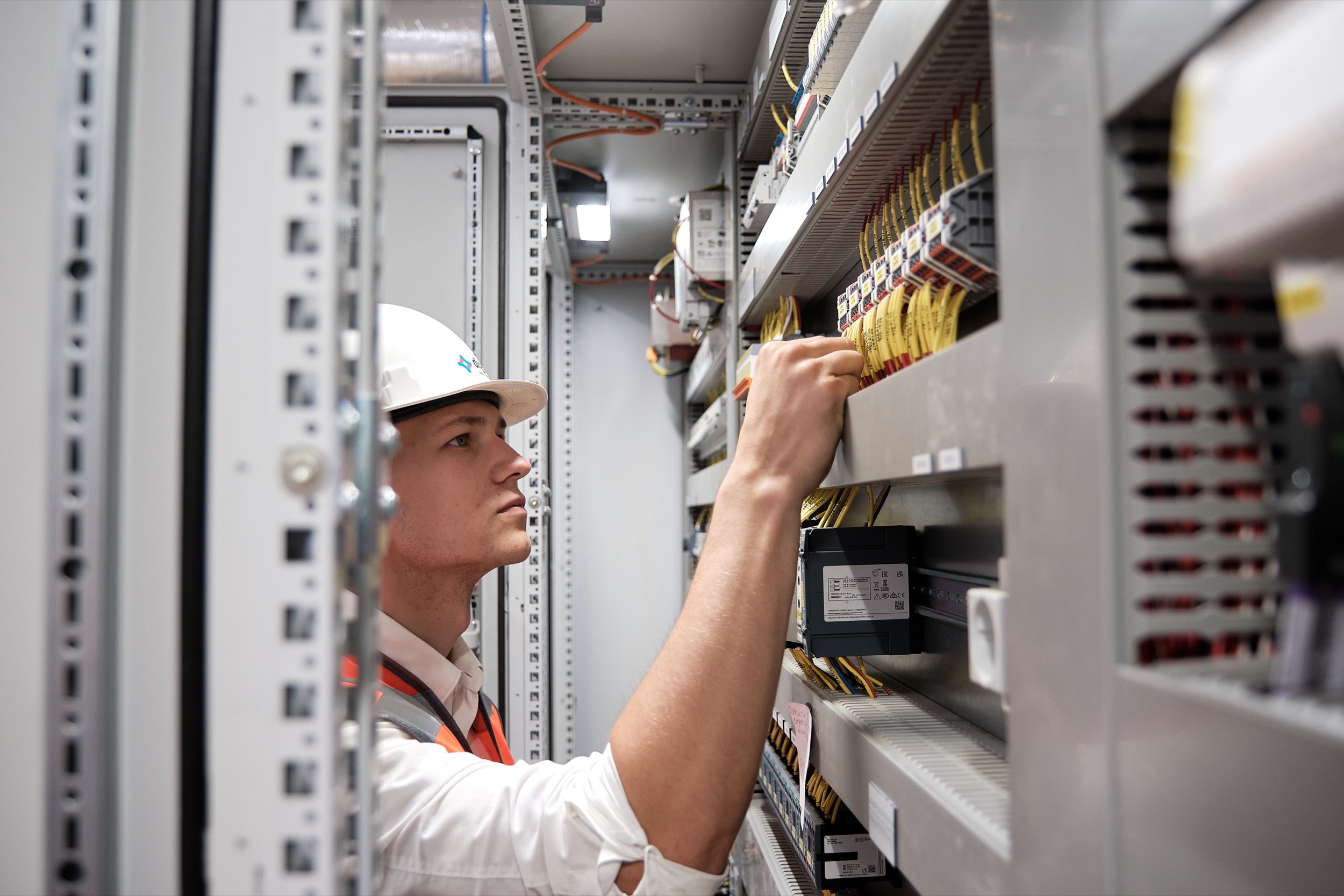 Elektricien in veiligheidsuitrusting werkt aan bedieningspaneel, RWZI Purmerend, Techniek Nederland — Stefan Segers Fotografie
