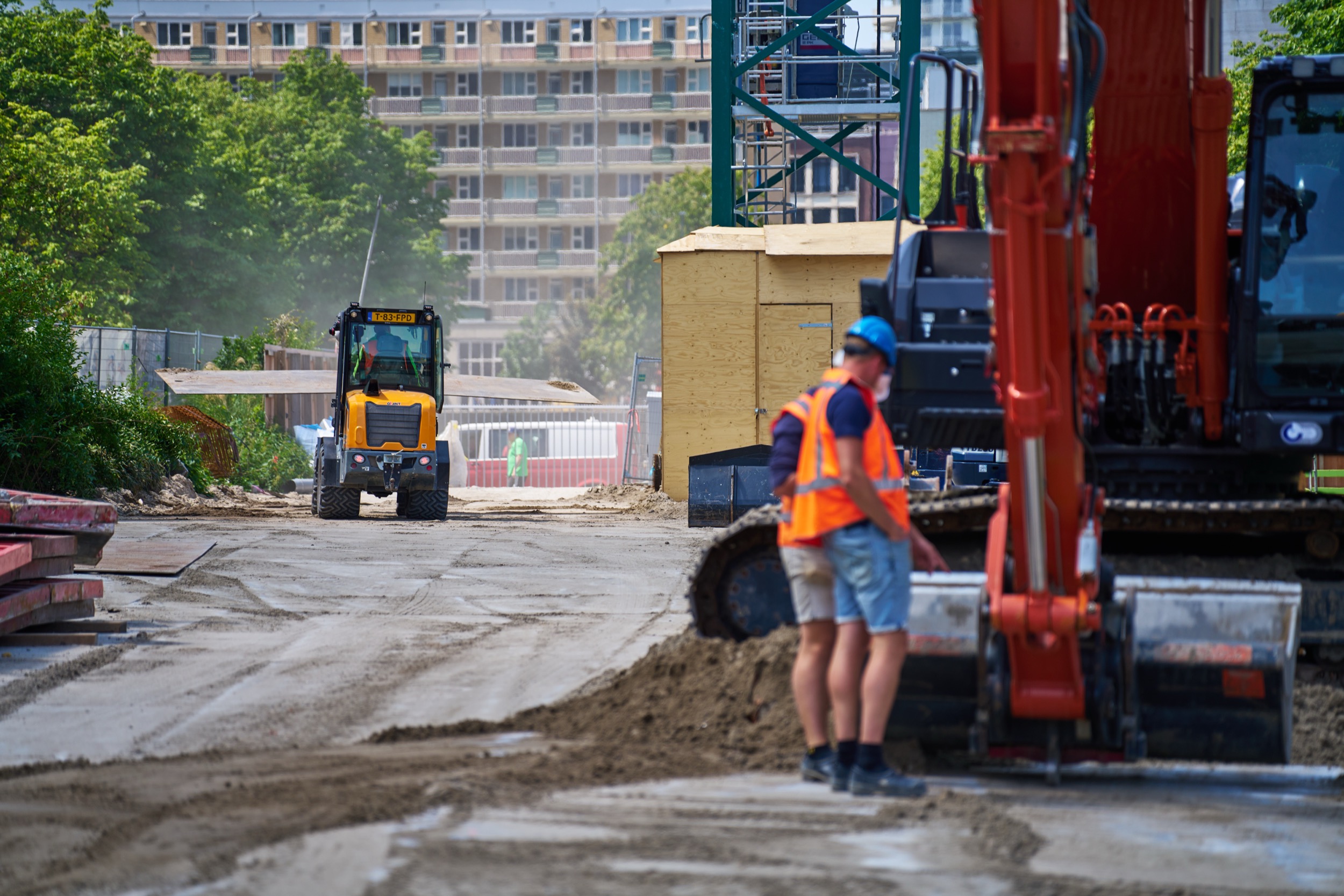 Bouwvakkers in oranje veiligheid op actieve bouwplaats Rotterdam, zware machines en grond — Stefan Segers Fotografie