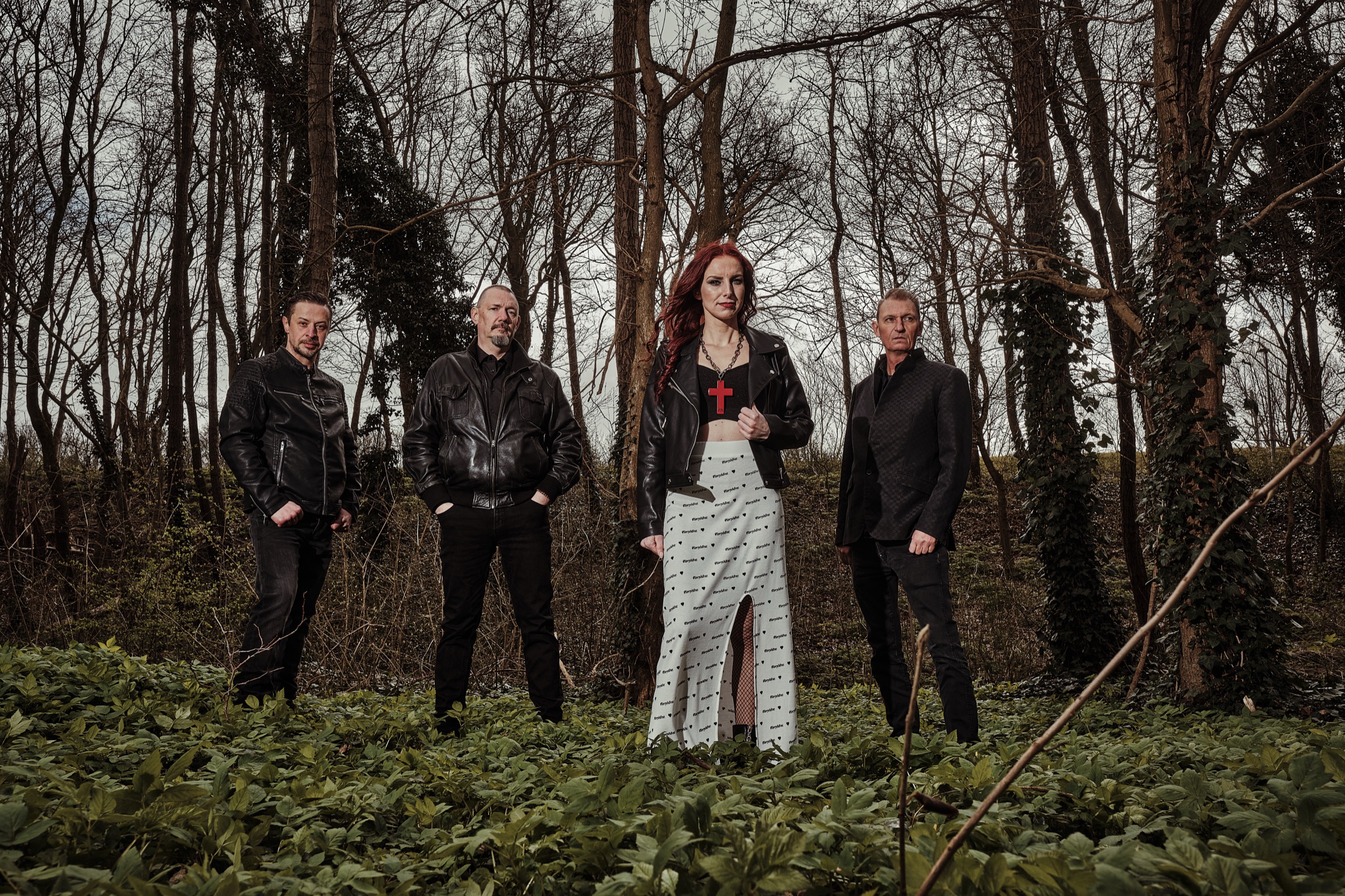 Vier bandleden in zwarte leren jassen poseren in bosomgeving, Heavy Metal band Killed in Music — Stefan Segers Fotografie