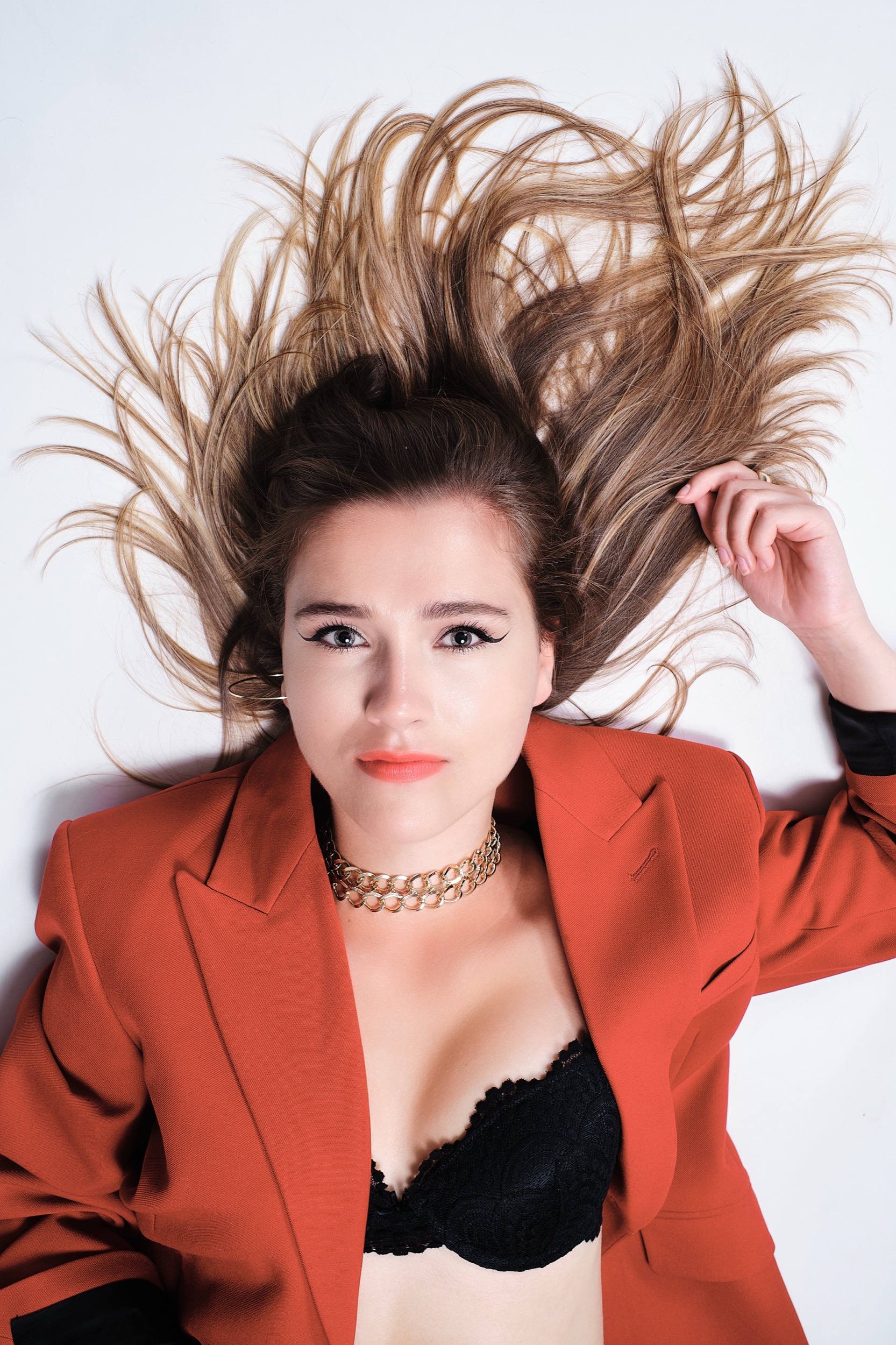 Vrouw in rood blazer met vliegend haar, artistiek portret in fotostudio, Zoetermeer — Stefan Segers Fotografie