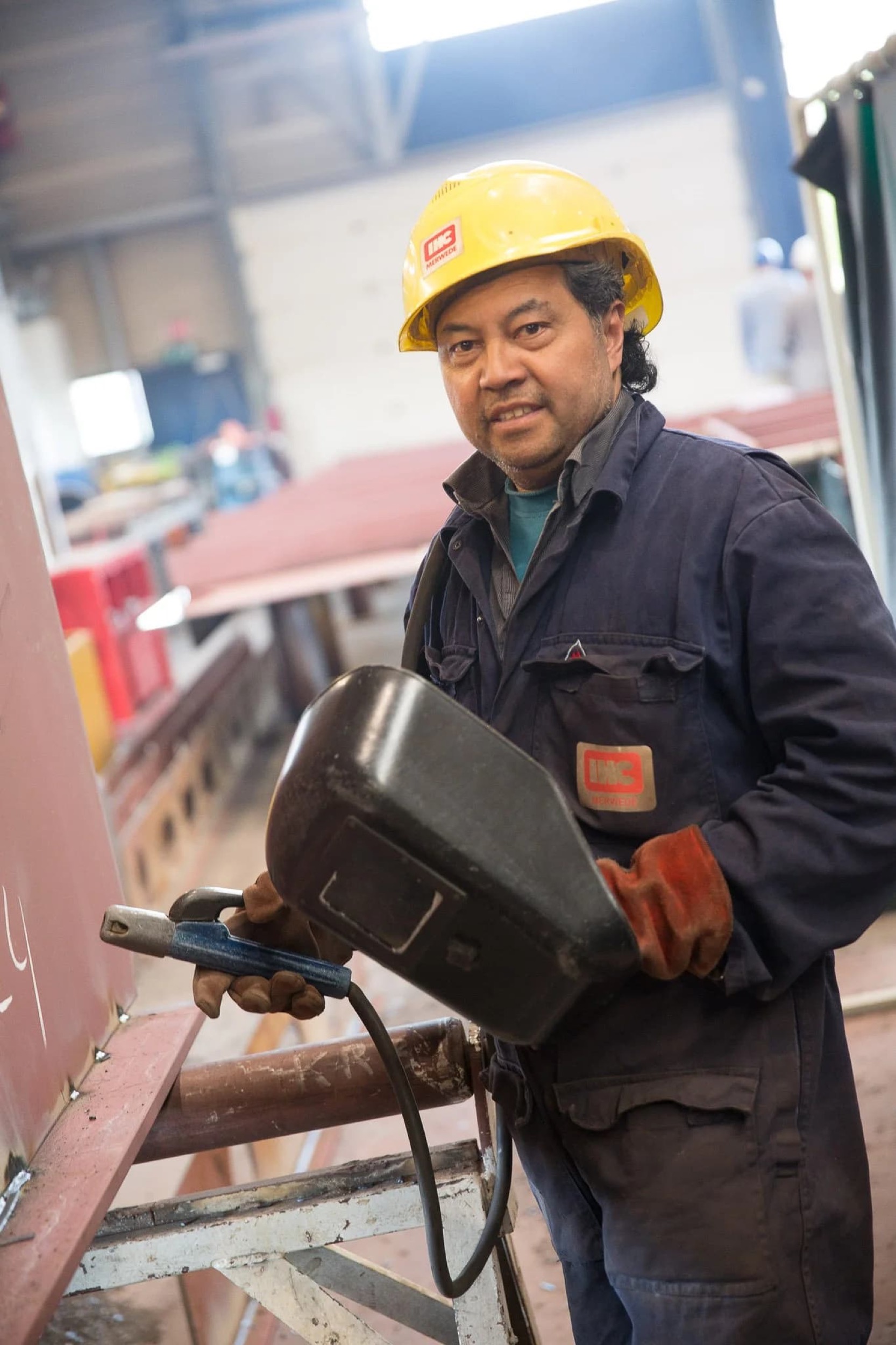 Monteur in gele veiligheidshelm werkt met elektrisch gereedschap op bouwplaats, professionele reportage — Stefan Segers Fotografie