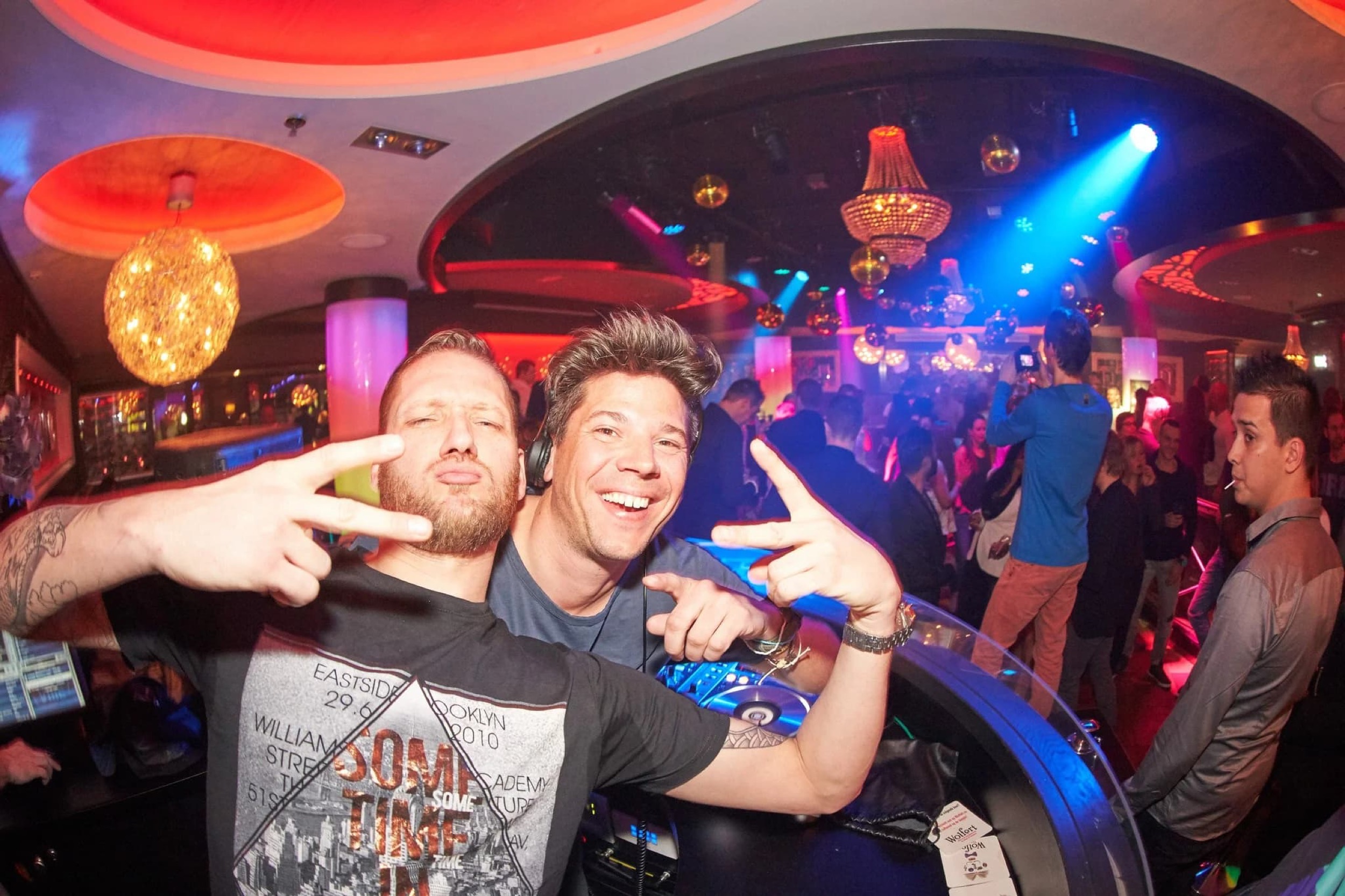 DJ en presentator maken plezier achter de decks op feestlocatie, neon verlichting, evenementfotografie — Stefan Segers Fotografie