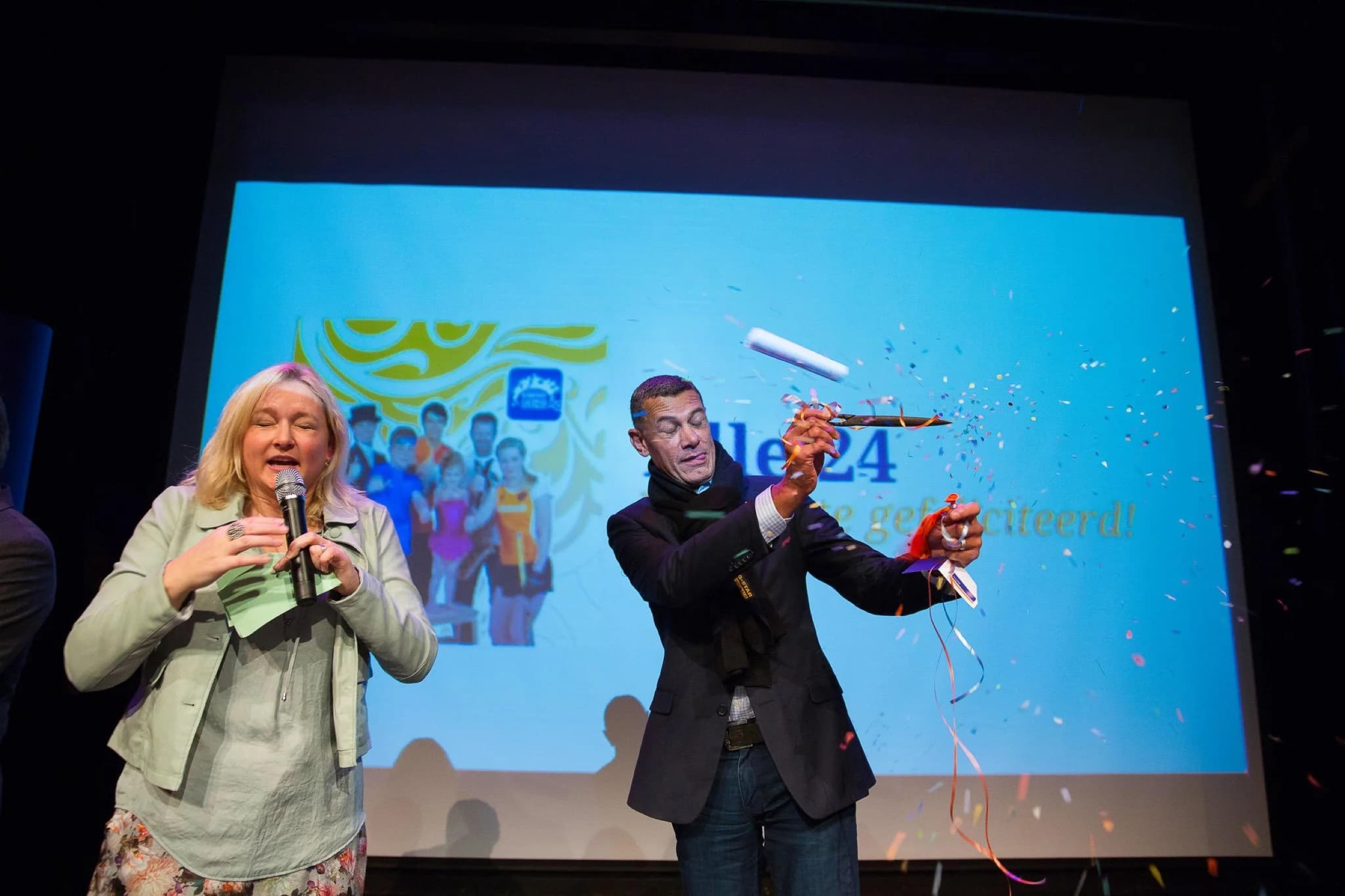 Twee sprekers presenteren op podium voor groot scherm, zakelijk evenement met interactieve demo — Stefan Segers Fotografie